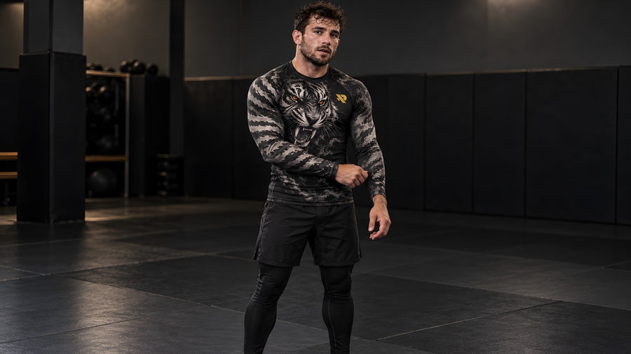 Combattant debout sur le tatami en rash guard Rashu Tigre, short et spats